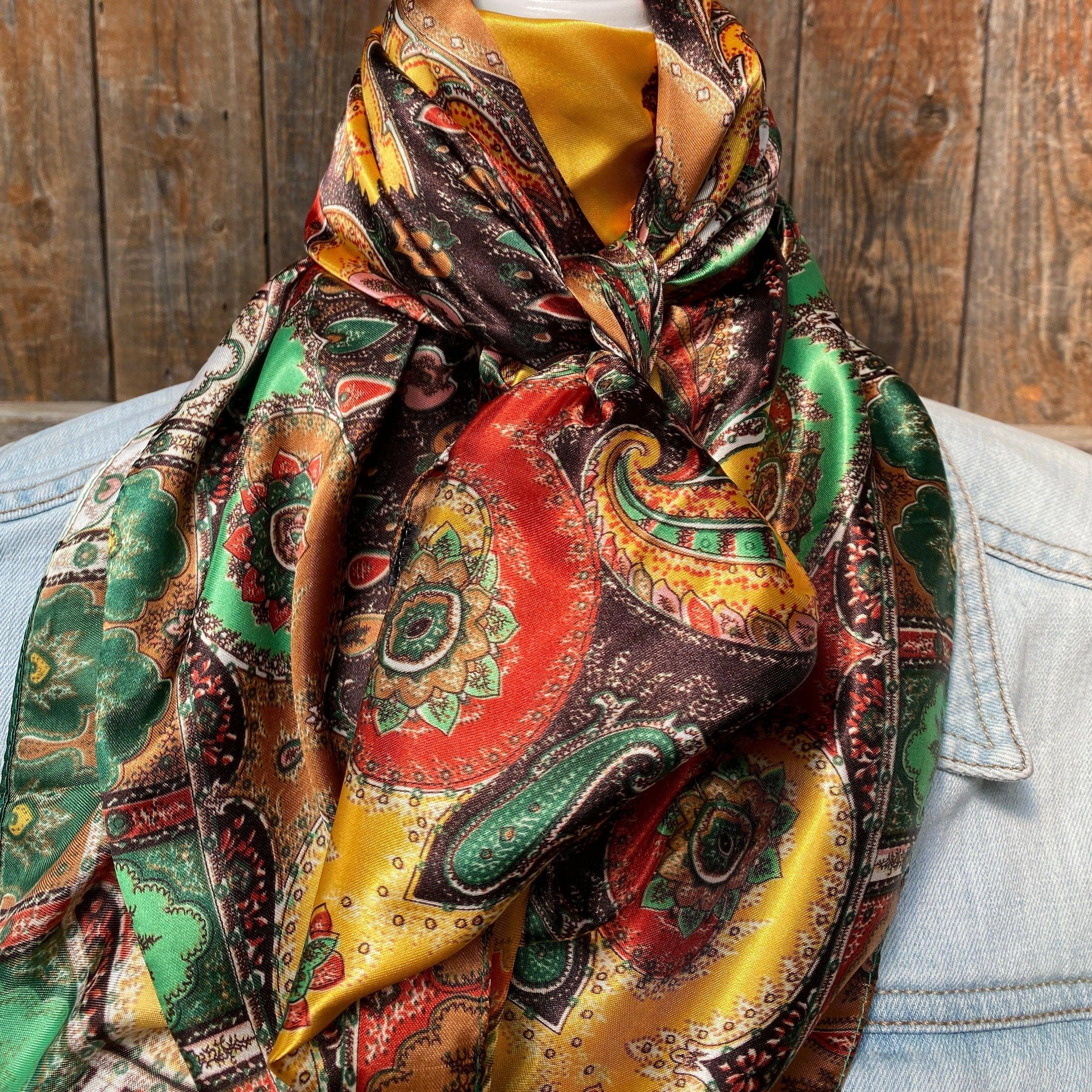 Colorful paisley silk scarf draped over a denim jacket with rustic wooden background