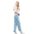 Woman wearing a casual white top with light wash wide-leg jeans and studded western bracelet