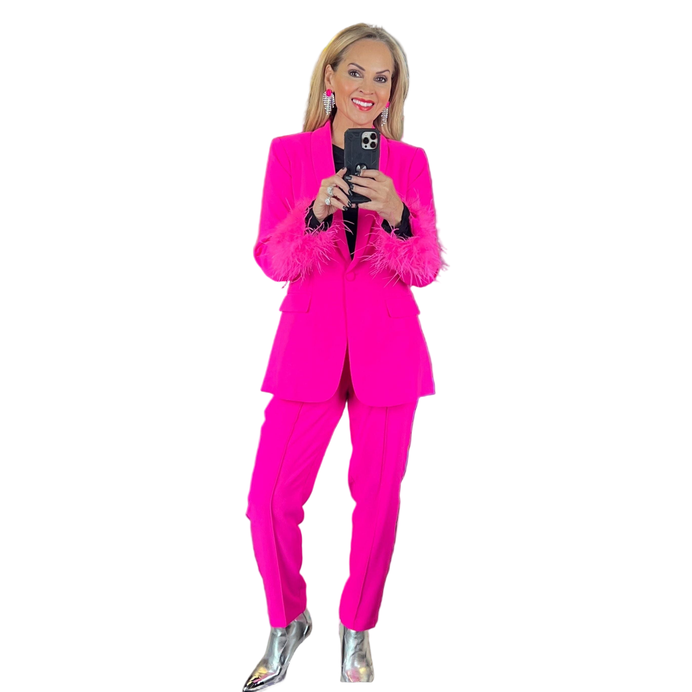 Woman in a hot pink suit with feathered cuffs, silver metallic boots, and statement earrings