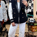 Navy double-breasted blazer with gold buttons and striped cuffs styled with white pants and layered necklaces in the Coulee Creek boutique